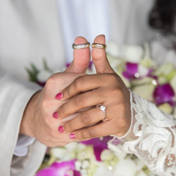 wedding couple showing rings on thumbs