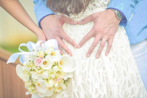 creative shot of groom forming a heart with hands