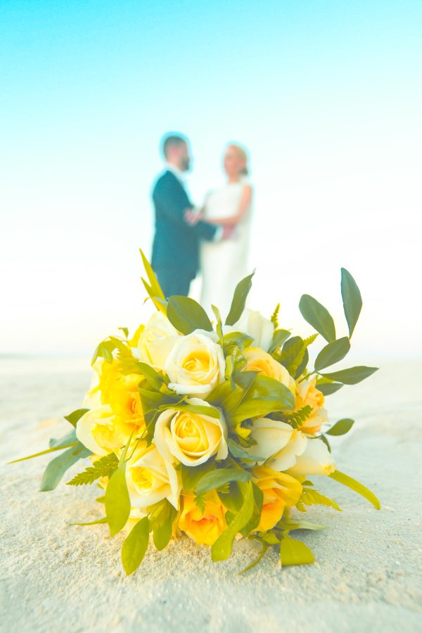nice couple posing at the back of bouquet on beautiful beach