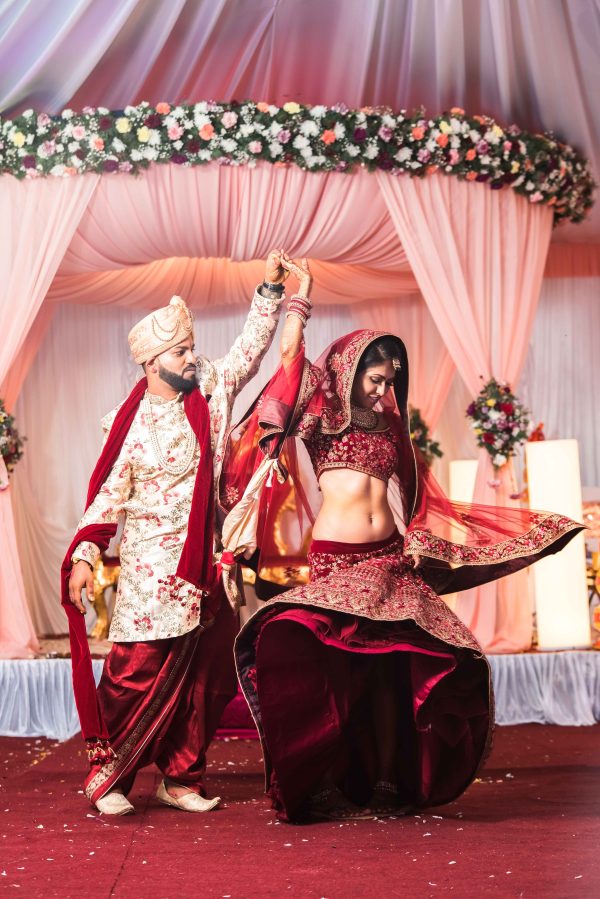 Husband and wife dancing in Indian attire after wedding ceremony 
